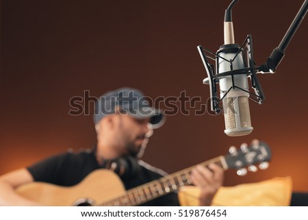 Young man singing in direct on musical studio.