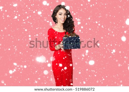 people, luxury, holidays and sale concept - picture of lovely woman in red dress with shopping bag. over snow background portrait