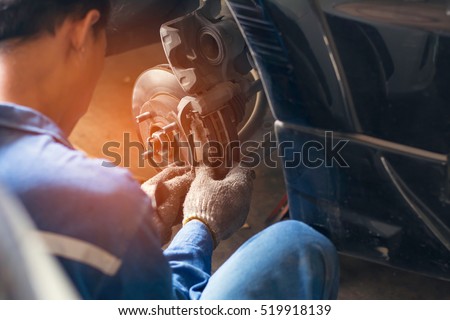 Selective focus disc brake on car, in process of new tire replacement,Car brake repairing in garage Royalty-Free Stock Photo #519918139