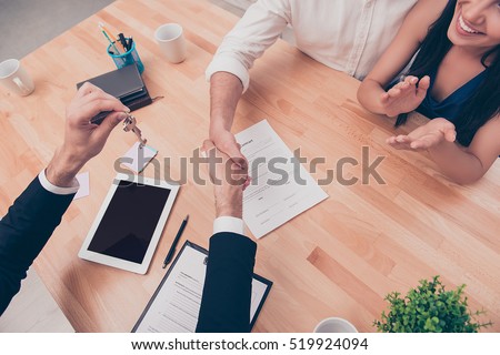 Broker giving keys of new house and handshaking with customer Royalty-Free Stock Photo #519924094