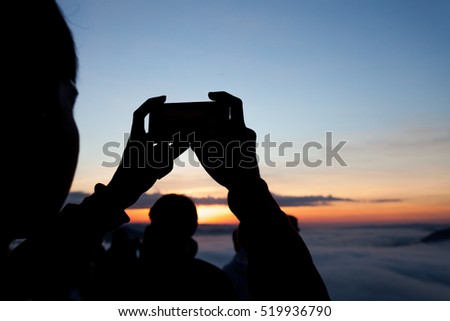 Men hands holding mobile phone at sunrise