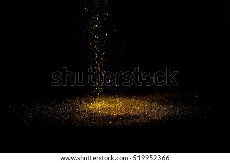 Sprinkle gold dust on a black background with copy space. Royalty-Free Stock Photo #519952366