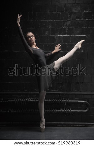 Charming dancer training near the black wall