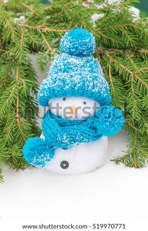 Snowman in a knitted hat and fir branches. Christmas decorations.