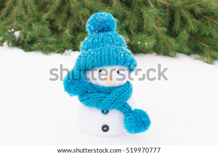Snowman in a knitted hat and fir branches. Christmas decorations.