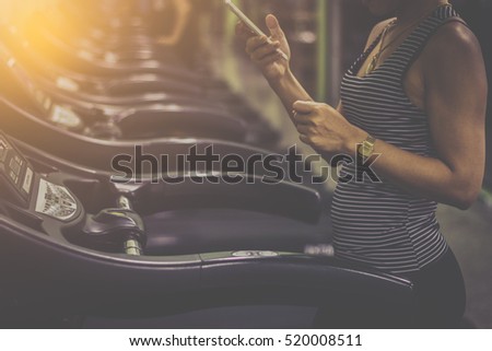 Woman Running On Treadmill At Gym and holding a phone / soft focus picture // Vintage concept 