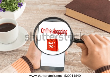 Online shopping and modern lifestyle concept. Women hands Use the magnifying glass screen smart phone for online shopping on the desk.