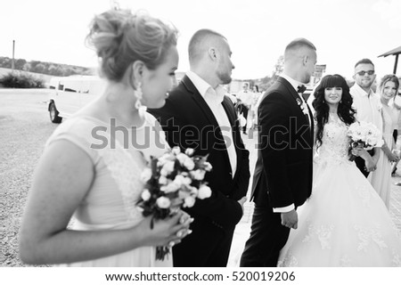 Wedding couple and bridesmaids with best mans background wedding quests. Black and white photo