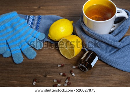The composition of winter clothing (hat, gloves, scarf), hot tea with lemon and drugs