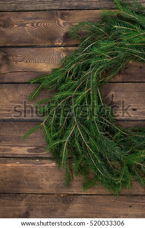 Christmas wreath of tree branches on wooden background