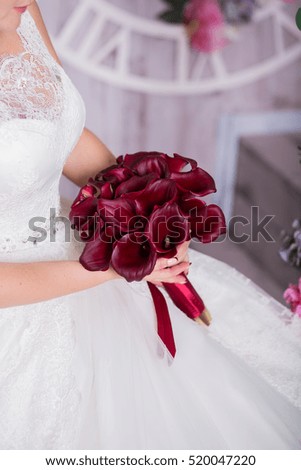 Bride holding a bouquet of purple callas, wearing a white wedding dress