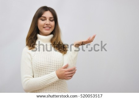 Gorgeous young brunette woman in warm knitted sweater on light grey background