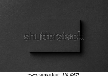 Mockup of blank business card stack at black textured background.