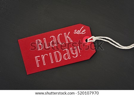 a red paper label with the text black friday sale written in it against a dark gray background