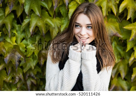 Portrait of young beauty brunette girl outdoors on green leaves background