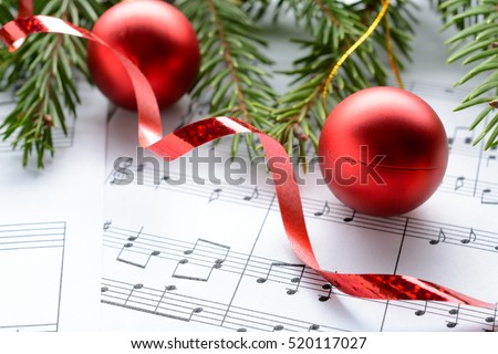 Christmas decorations and fir branch lying on notes sheet
