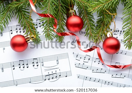 Christmas decorations and fir branch lying on notes sheet Royalty-Free Stock Photo #520117036
