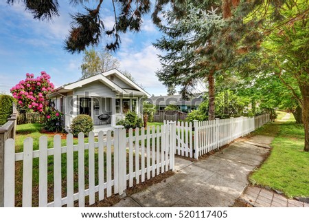 Cute craftsman home exterior with picket fence. Northwest, USA Royalty-Free Stock Photo #520117405