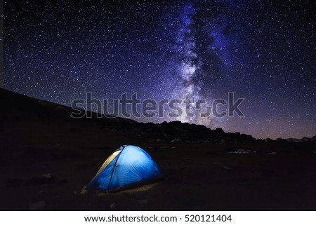 Tent with travelers under the amazing starry sky