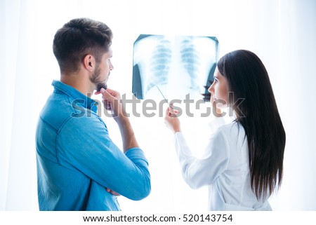 Young doctor showing the X-Ray photo of lung to her patient