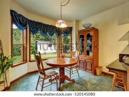 Separate breakfast nook with nice window view, furnished with carved wooden table set for two. Northwest, USA