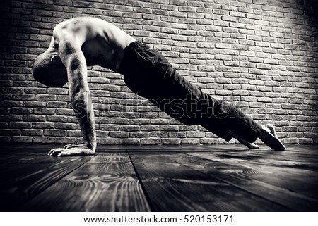 An experienced yoga instructor showing different yoga poses. Brick wall background. Healthy lifestyle. Meditation, concentration.