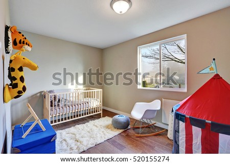 Nursery room interior with a crib , toys and dark hardwood floor. Northwest, USA