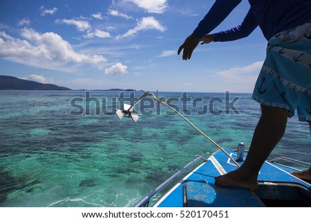 man drops anchor from the boat in lipe island, Thailand