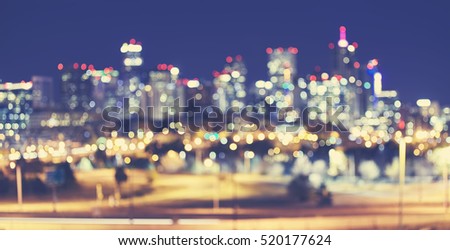 Vintage toned blurred Denver city lights at night, urban abstract background.