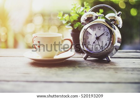 Start up concept.Coffe cup,alarm clock,notebook.morning coffee day start.vintage tone Royalty-Free Stock Photo #520193209
