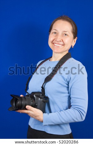 Happy female photographer, isolated over blue background