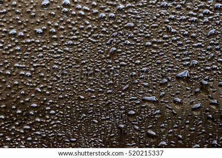 Black drops of oil stains on glass background.