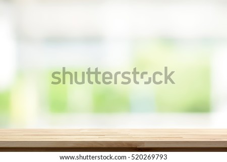 Wood table top on blur white green kitchen window background - can be used for display or montage your products (or foods)