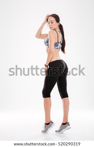 Full length aerobic model in studio. stands sideways. isolated white background