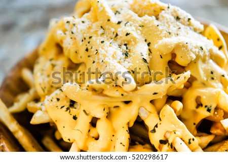 Melting cheddar cheese over the top of french fries  Royalty-Free Stock Photo #520298617