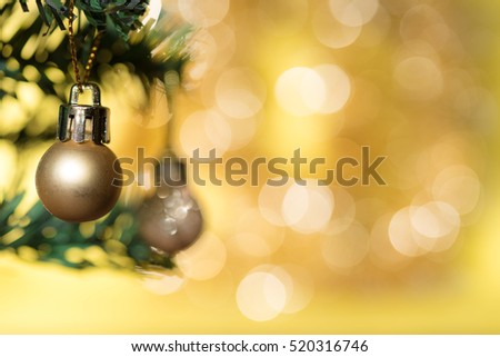 Golden christmas ball ornament decoration hanging on fir tree over gold circle bokeh blur background with copy space for text, greeting card happy new year 2017