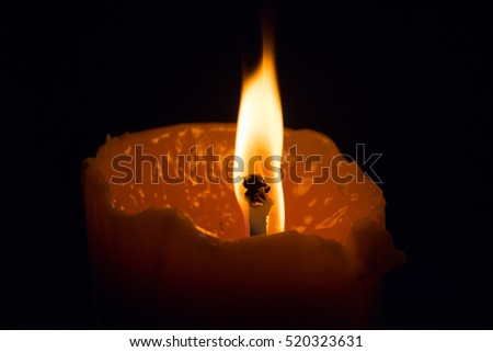 One candle light burning in the dark background