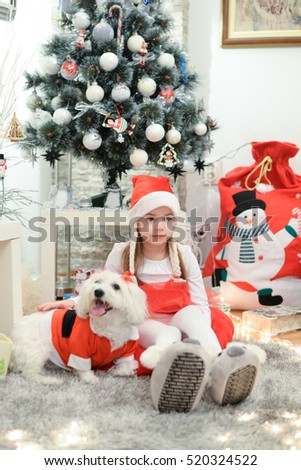 Girl and dog near the Christmas tree