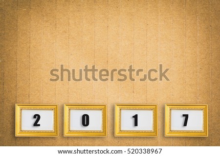 2017 in gold photo frame on brown paper texture ,Happy new year