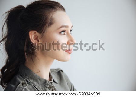 Woman in shirt in studio. in profile. isolated gray background