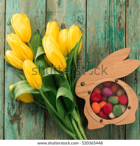 Easter background yellow tulips on wooden table, Rabbit, eggs,nest candy