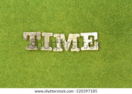 time: paper cut alphabet on green grass