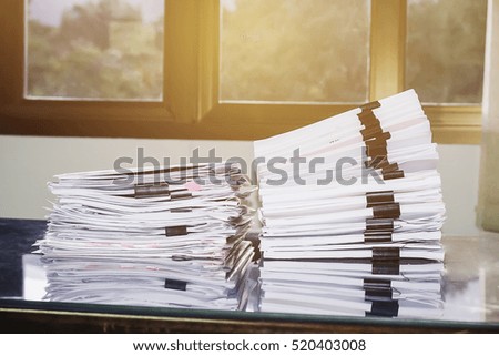Paper stack on the desk related to business functions. With morning light,soft focus 