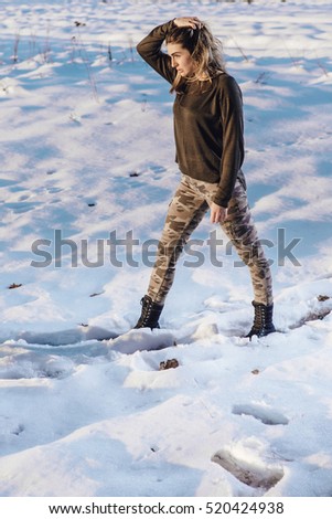 Military style portrait of cute lady on winter background