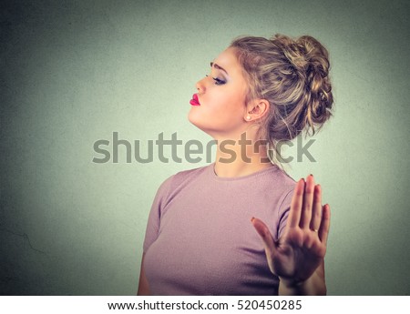 Snobby young annoyed angry woman with bad attitude giving talk to hand gesture with palm outward isolated grey wall background. Negative human emotion face expression feeling body language Royalty-Free Stock Photo #520450285