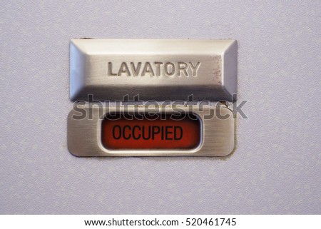 Occupied lavatory sign on the commercial airlines. Royalty-Free Stock Photo #520461745