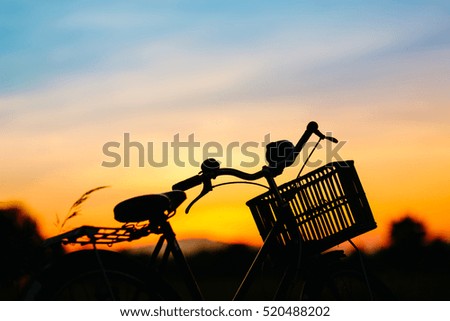 Silhouette picture of bicycle in the evening,the sunset light in summer season.