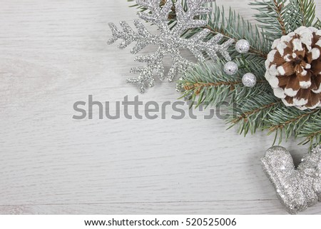 Christmas Background with silver snowflake, snow cone and branch pine and silver boot on white wood 