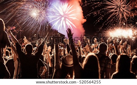 cheering crowd watching fireworks at New Year - holiday celebration background Royalty-Free Stock Photo #520564255