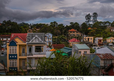 Cityscape of Dalat in Vietnam in the evening light. rooftop panorama. Rice fields, beautiful landscape.Beautiful houses with tile roofs  in the Da Lat city on the blue sky background in Vietnam. 